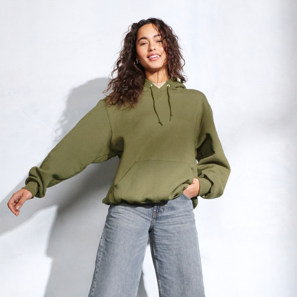 female model wearing russell athletic moss green hoodie sweatshirt and jeans